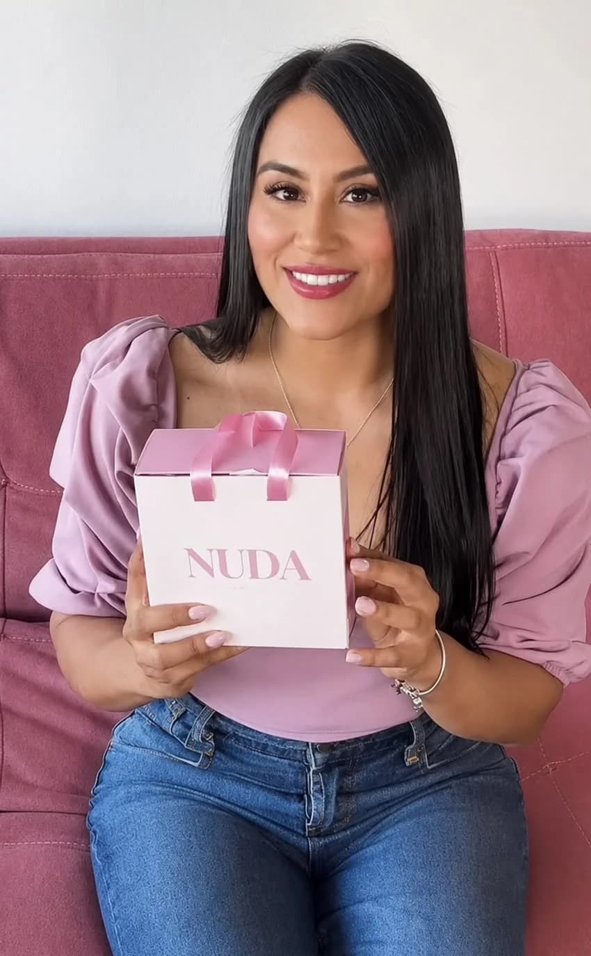 Mujer con la bolsa de regalo NUDA en el sofá